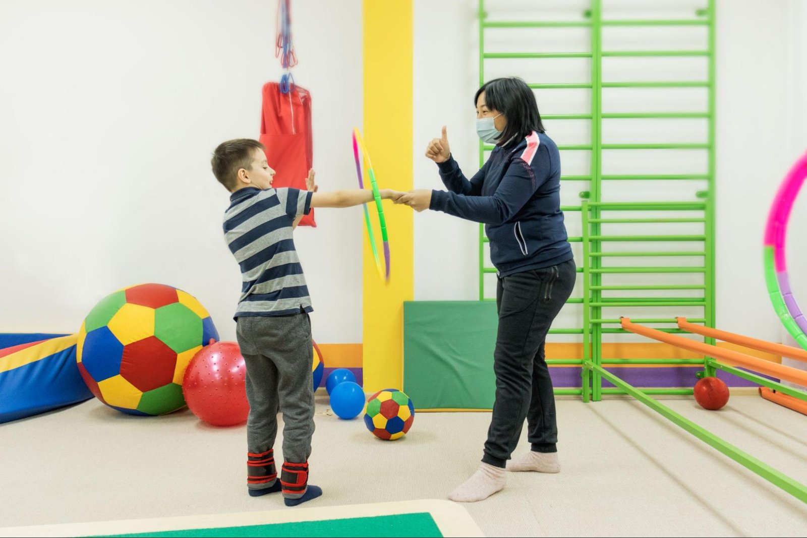 An occupational therapist helps the child with sensory integration exercises.