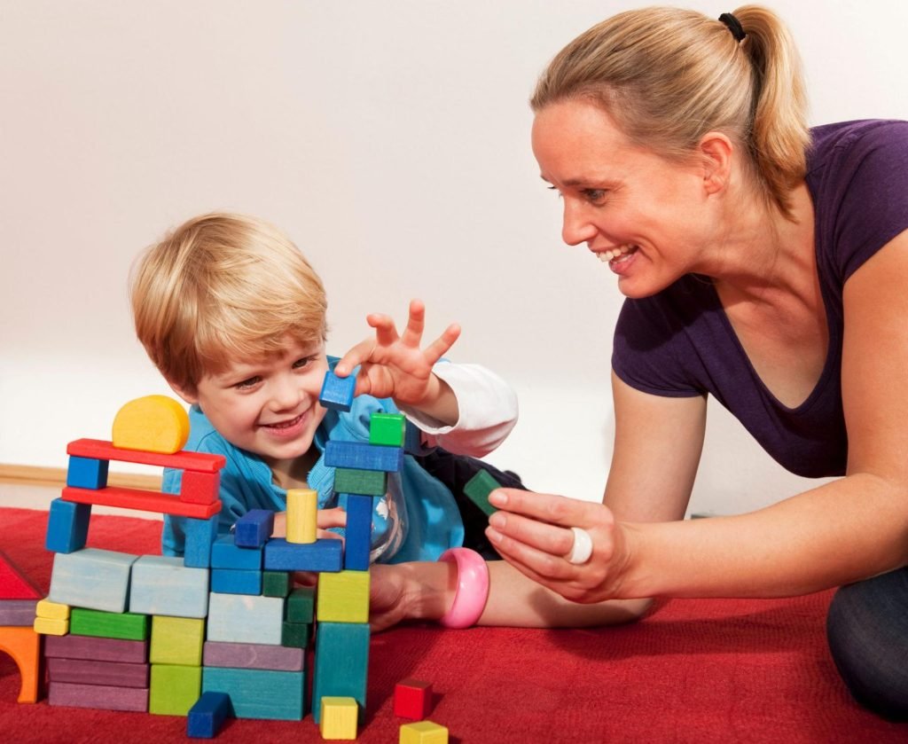 Mom and son play with building blocks to support fine motor skills.