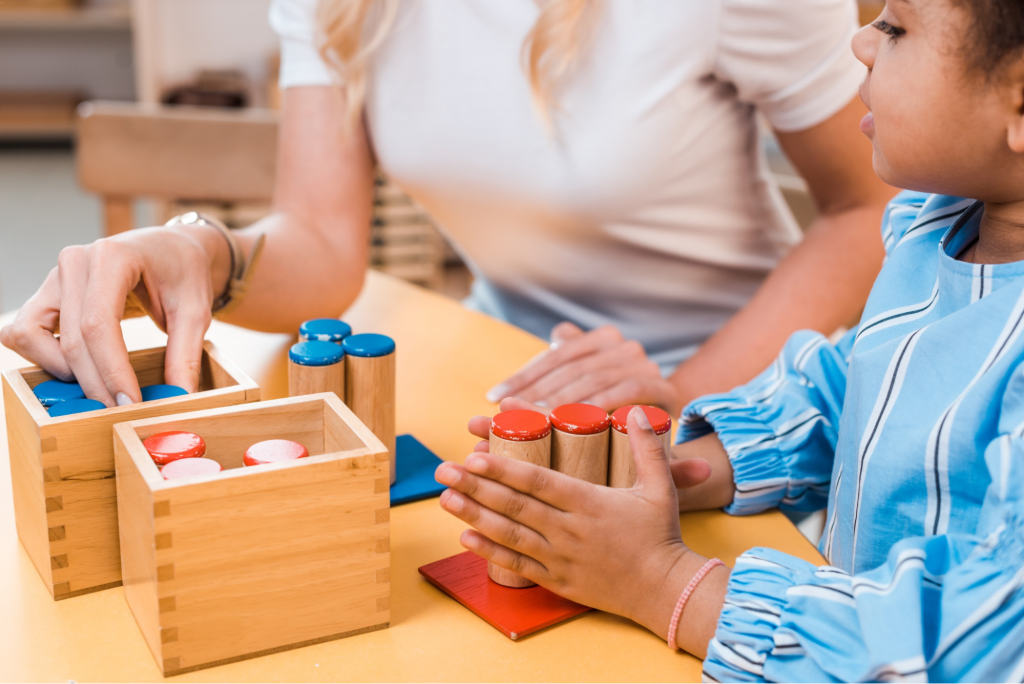 An occupational therapist guides a child using wooden dowels and blocks to support motor skill development and coordination.