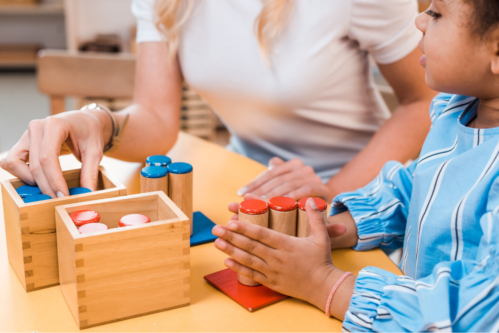 An occupational therapist guides a child using wooden dowels and blocks to support motor skill development and coordination.