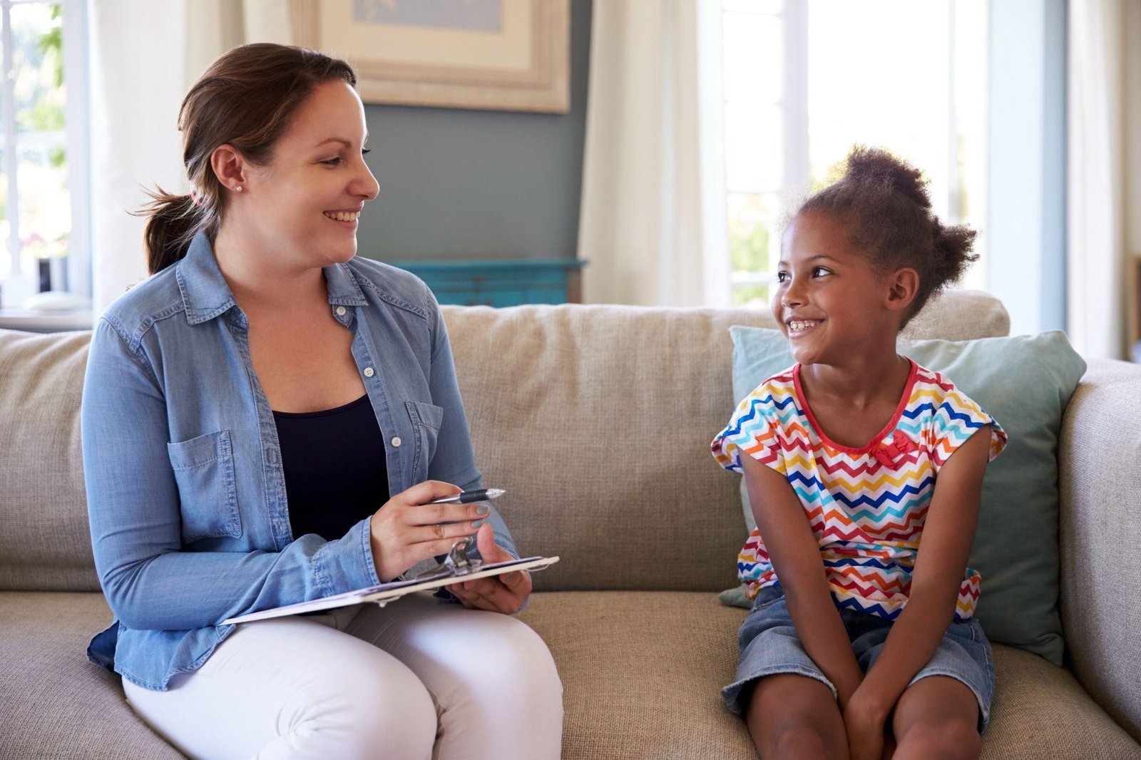 A pediatrician talking to a young patient to check the progress of her communication skills.