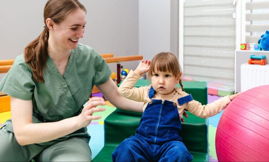 An occupational therapist assists a young child with a coordination disorder during the motor skills activity.