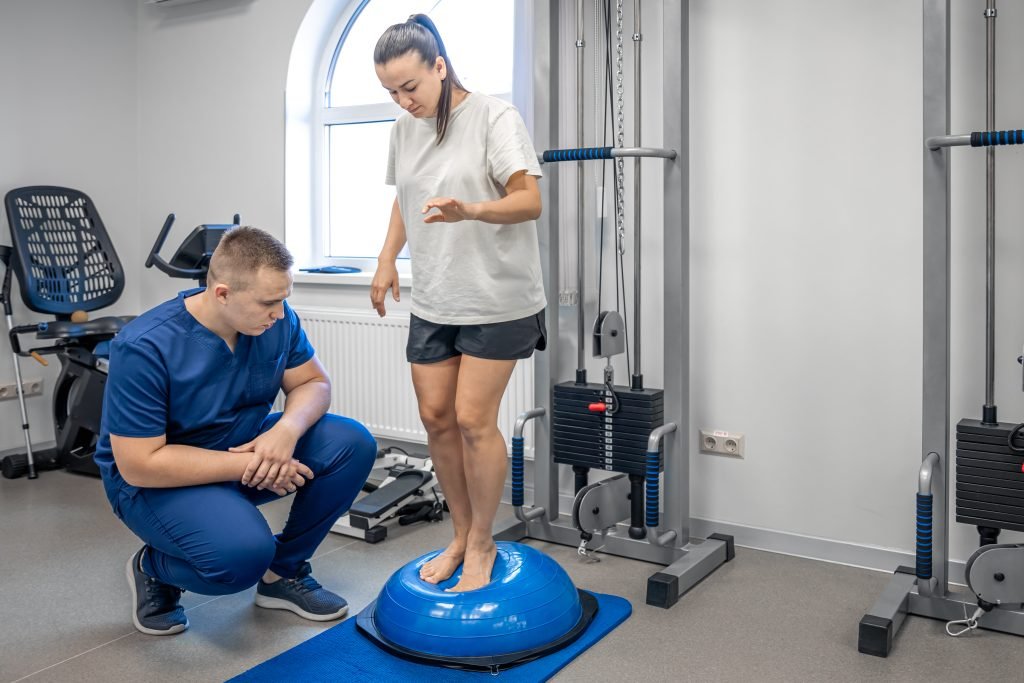 A doctor guides a woman through balance exercises at a rehabilitation center.