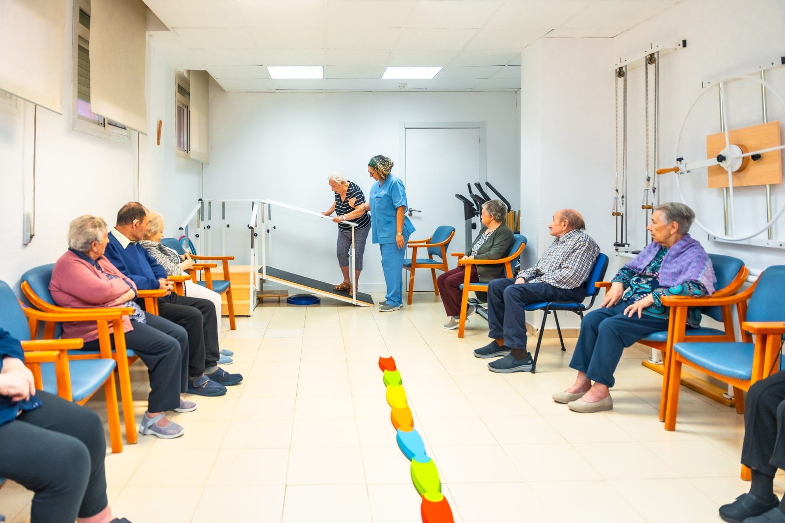 A group of seniors work with a physical therapist at a rehabilitation center.