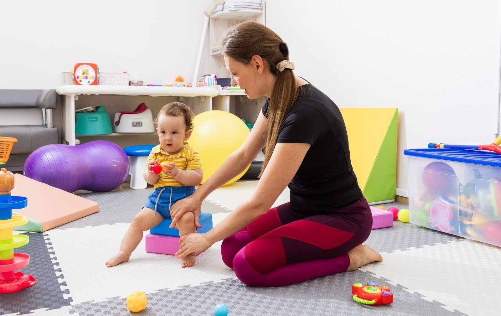 Physiotherapist guiding a young child with coordination difficulties through motor skill exercises 